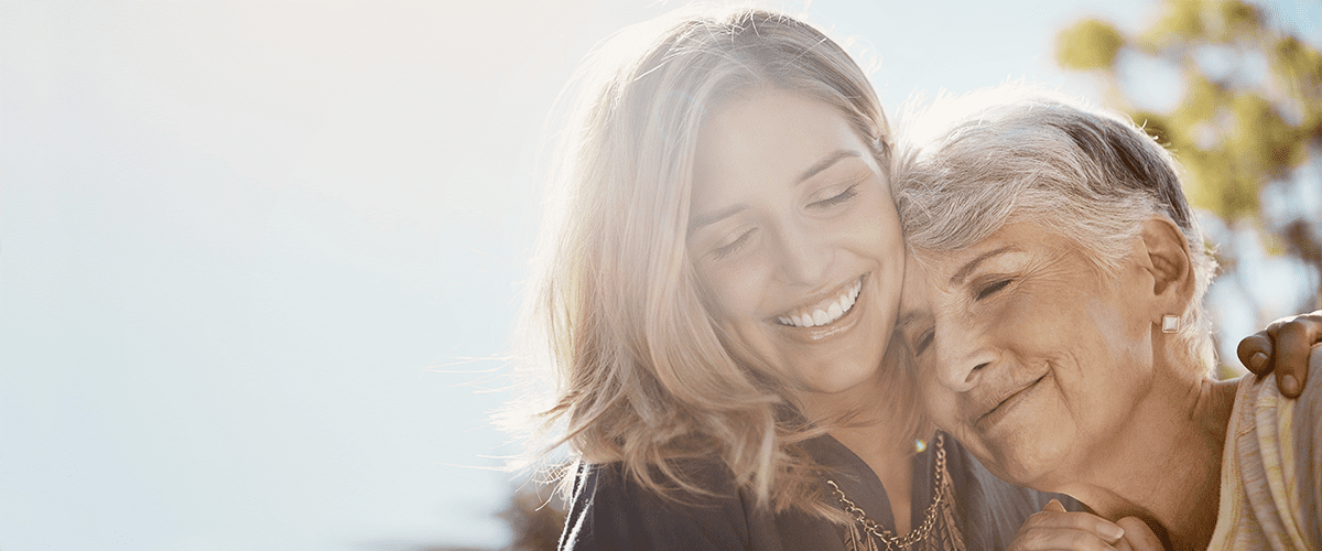 A woman smiling with her hair blowing in the wind.